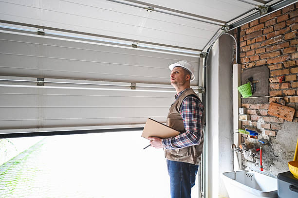 construction worker inspecting garage door installation in residential building construction worker inspecting garage door installation in residential building